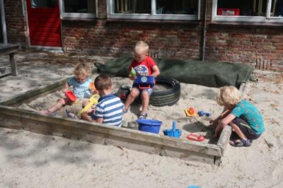 Kinderen spelen in de zandbak - Kids First COP groep